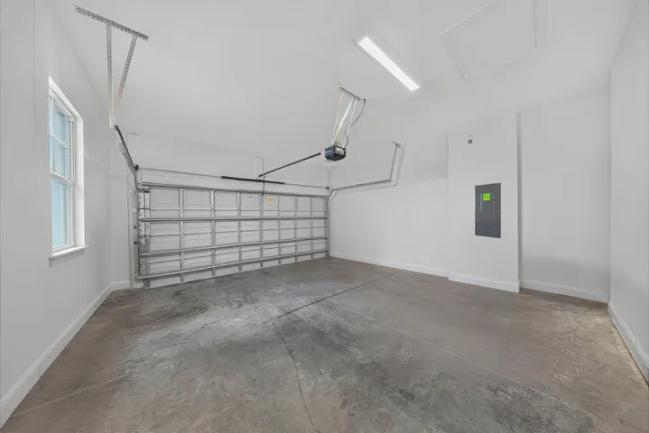 Spacious garage featuring a concrete floor, white walls, and a window for natural light