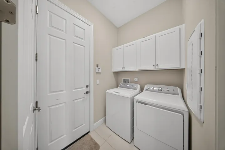 Laundry room with washer and dryer nd cabinets for storage