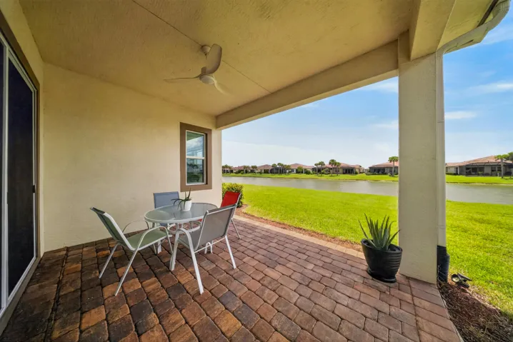 Covered patio featuring a ceiling fan and multi-toned paver flooring