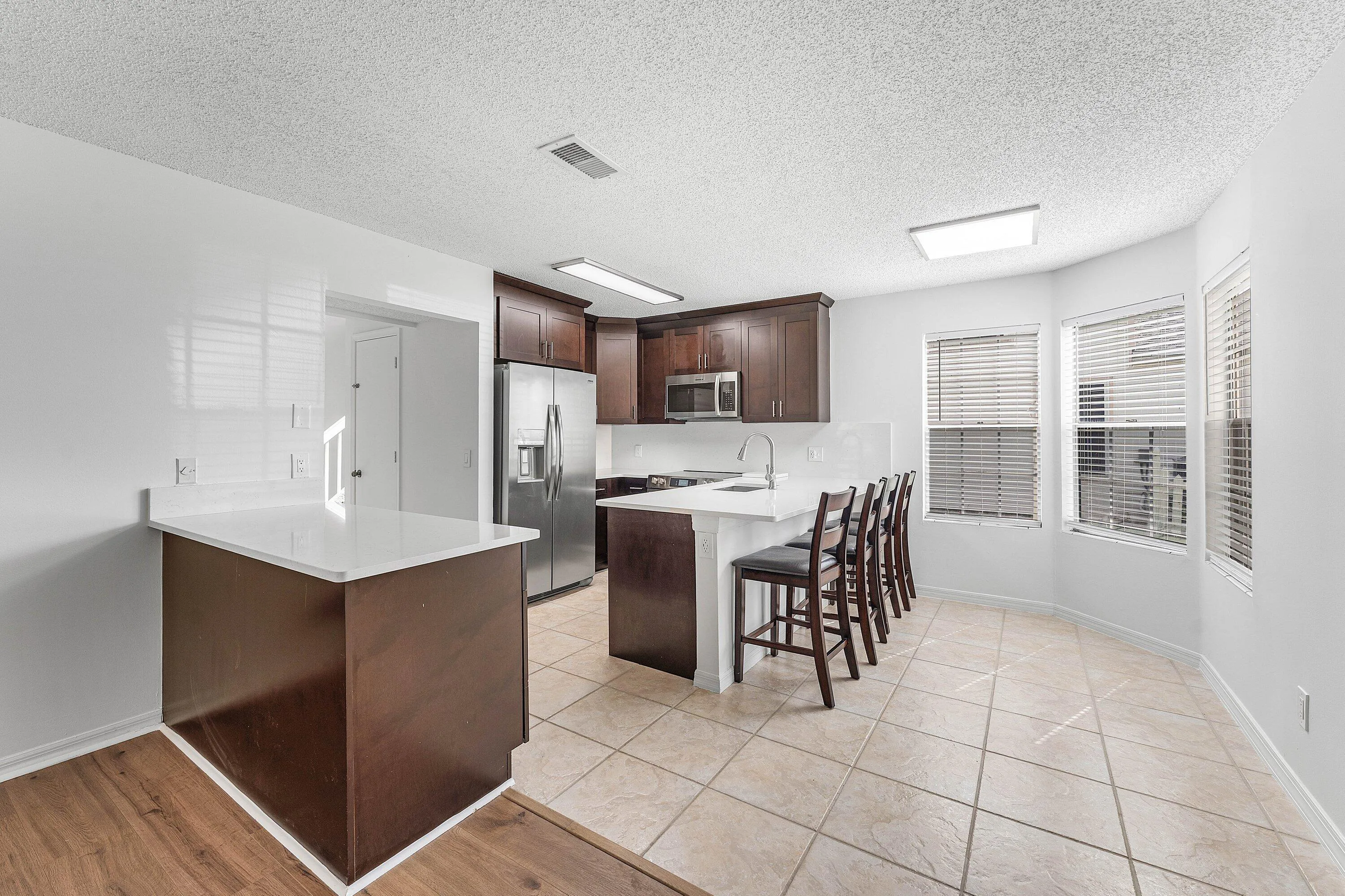 Kitchen featuring dark wood cabinetry, stainless steel appliances, and white countertops