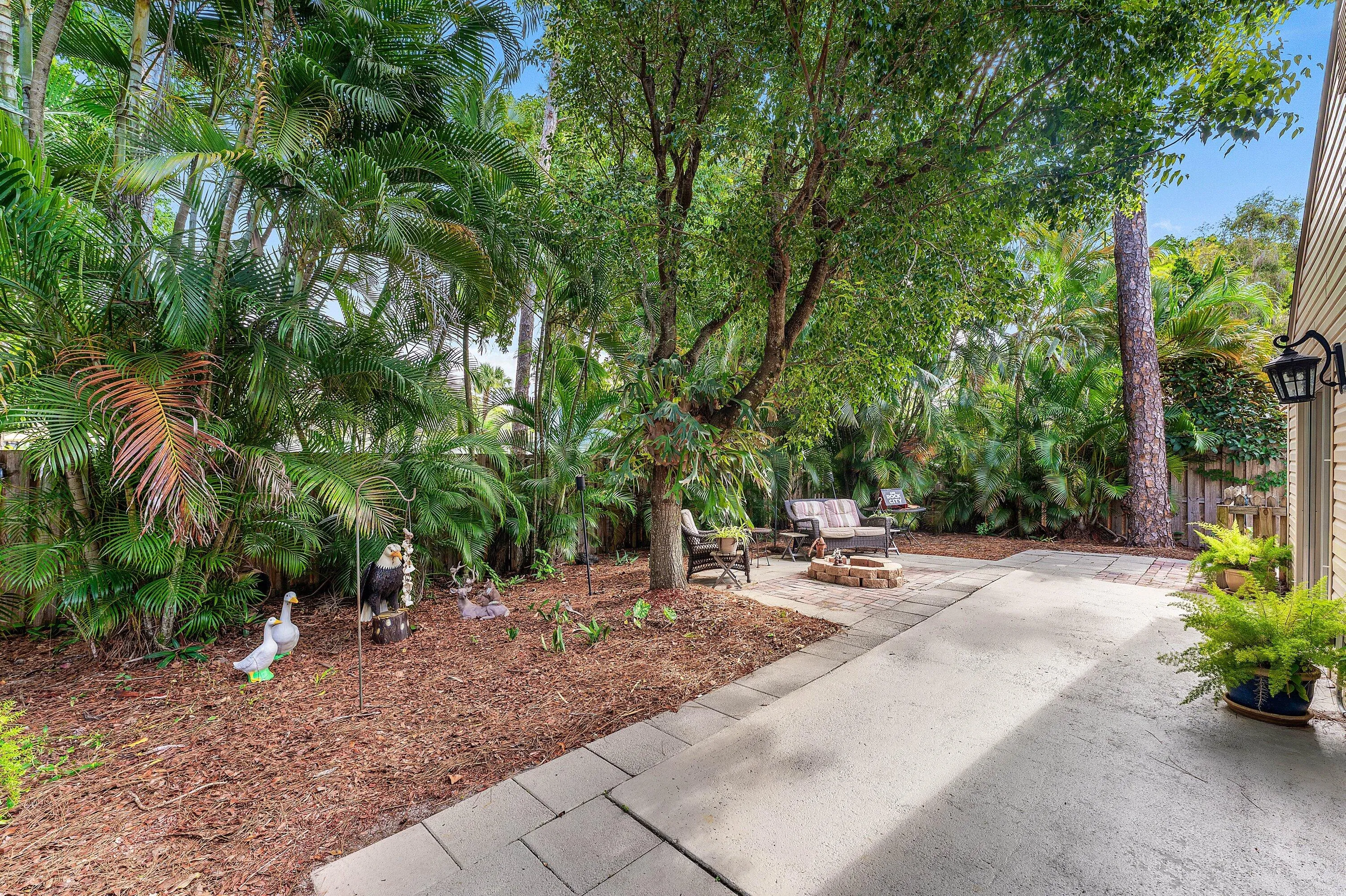 Private outdoor space featuring mature trees and lush tropical landscaping