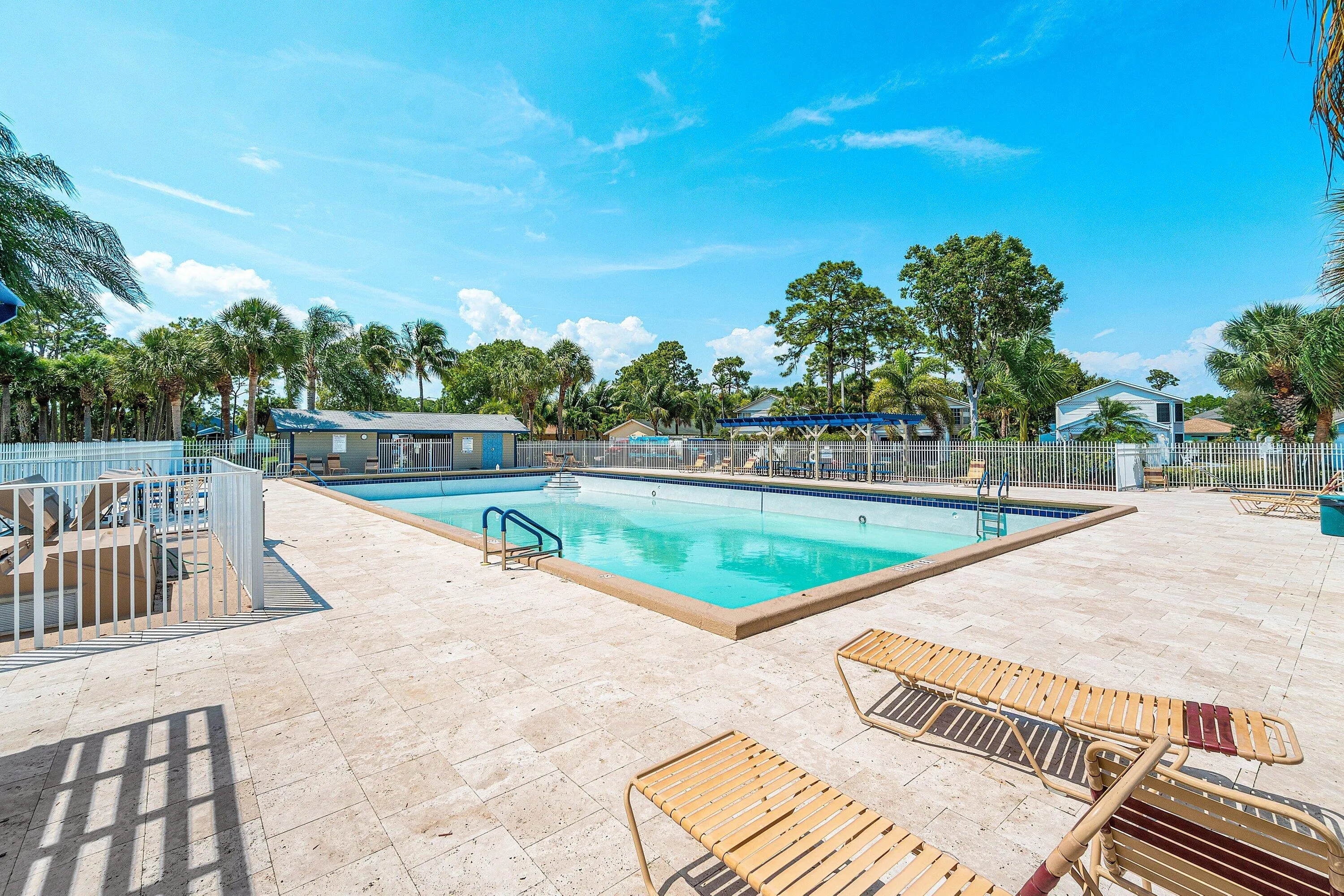 Expansive outdoor swimming pool with integrated entry steps and perimeter safety fencing