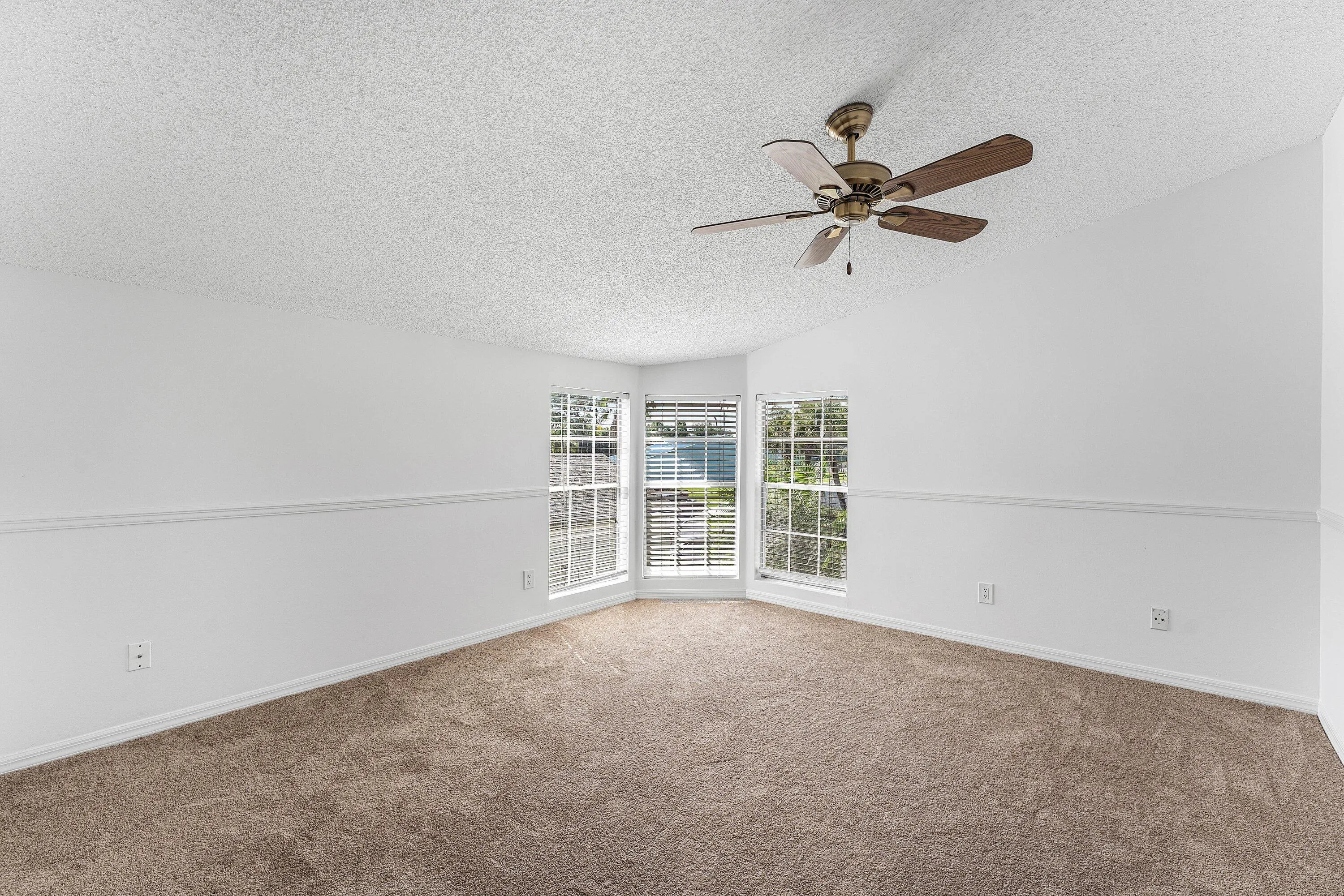 Neutral-toned carpet flooring complementing white walls with chair rail molding