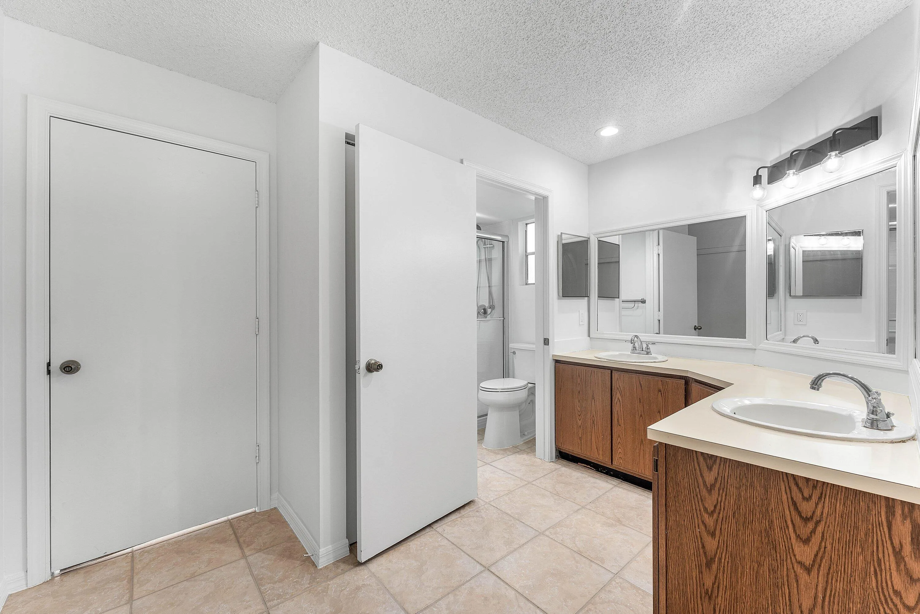 Dual vanity with wood-finish cabinetry and light-toned countertops