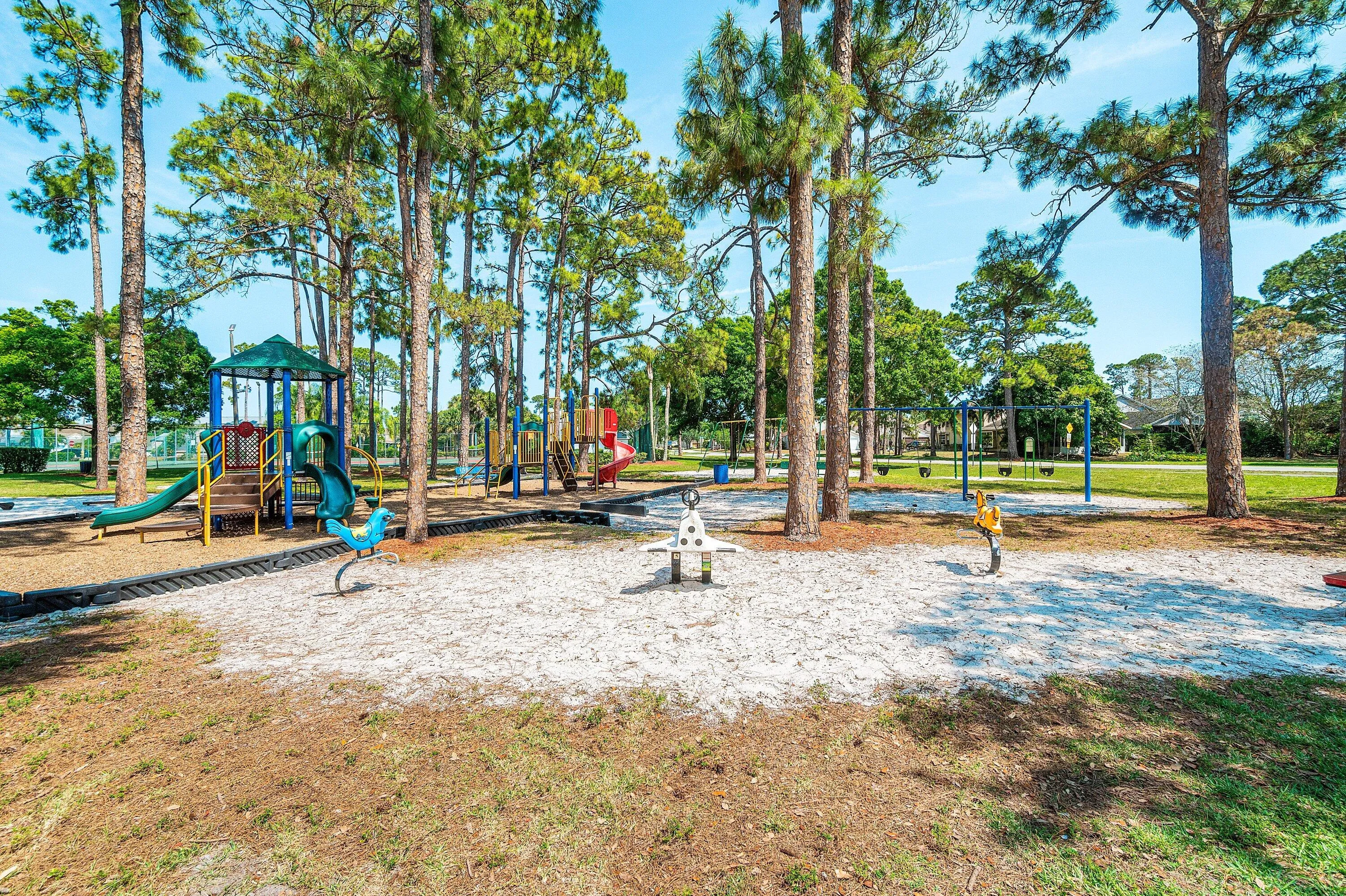 Community playground featuring multiple play structures and swings