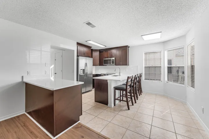 Kitchen featuring dark wood cabinetry, stainless steel appliances, and white countertops