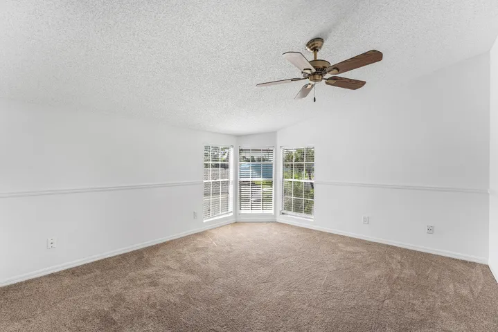 Neutral-toned carpet flooring complementing white walls with chair rail molding