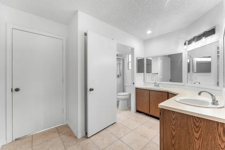 Dual vanity with wood-finish cabinetry and light-toned countertops
