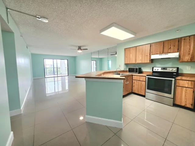 LARGE KITCHEN WITH LIVING ROOM/ DINING ROOM LEADING TO YOUR SPECTACULAR LAKE VIEW