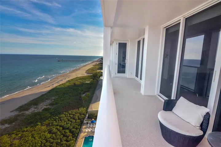 Spacious oceanfront balcony with glass railings and hurricane proof glass
