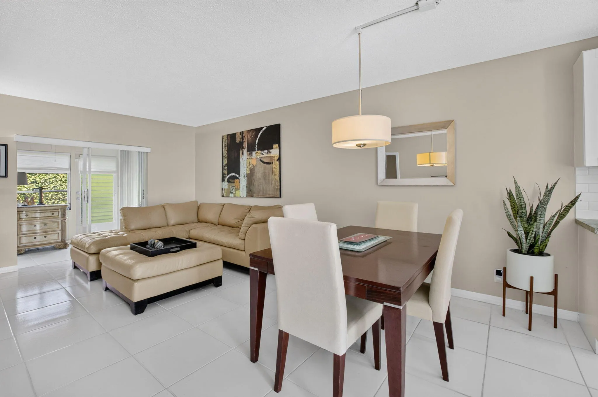 Open concept living space featuring neutral wall tones and large format tile flooring