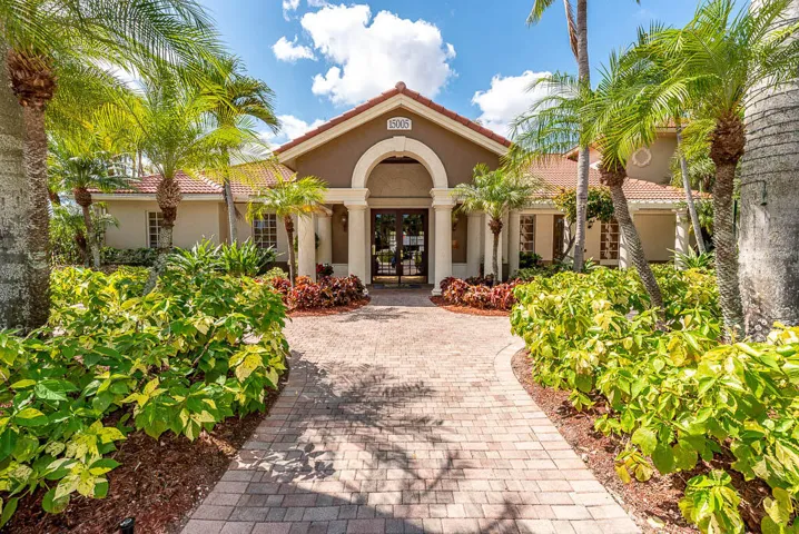 Mediterranean-style building featuring an arched entryway with columns, a barrel tile roof, and stucco exterior