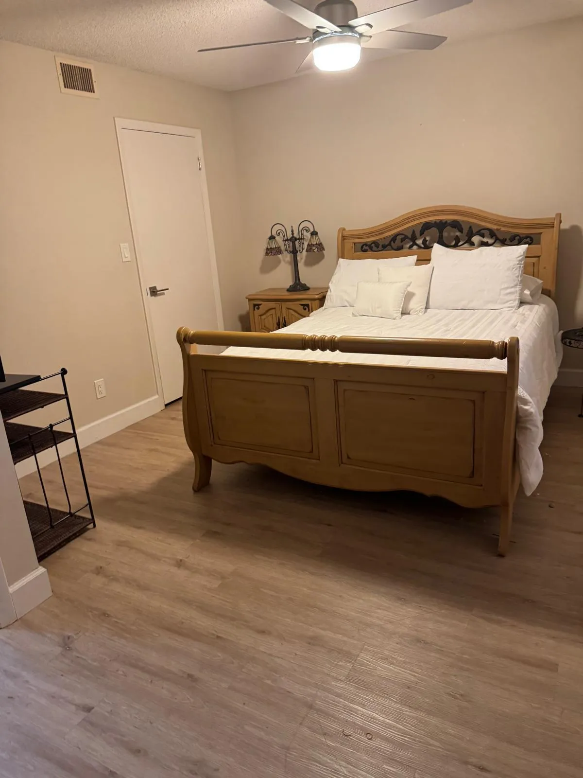 Neutral tone wall finishes, wood-finish flooring, and a ceiling fan with integrated lighting