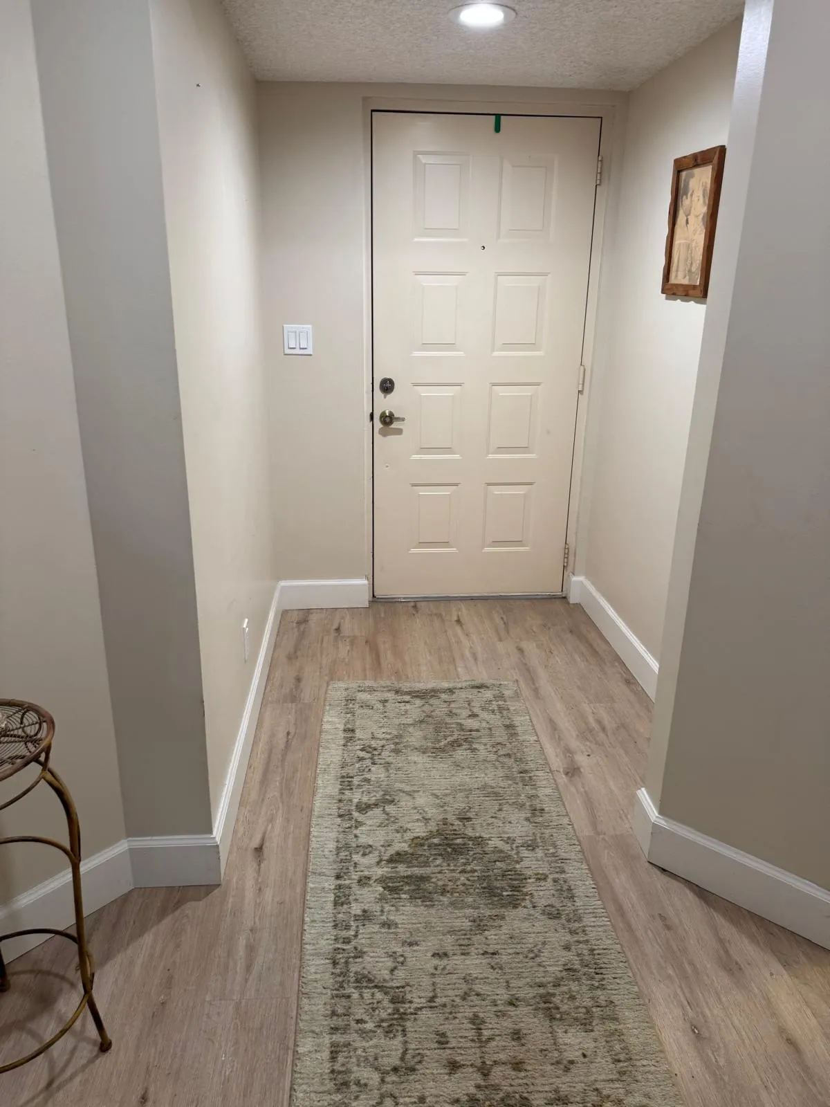 Entryway featuring a paneled door with polished hardware, overhead recessed lighting, and light wood-finish flooring