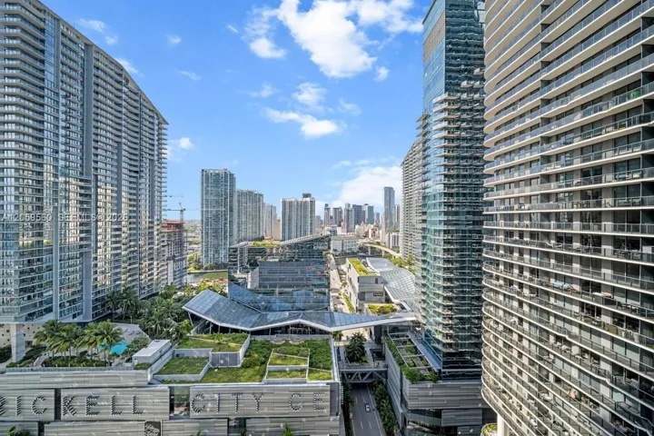 High-rise urban landscape featuring contemporary skyscrapers with extensive balcony rows, integrated glass-and-steel architecture, and elevated green-roof installations