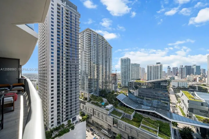 Covered private balcony featuring glass panel railings and tile flooring