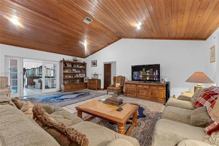LIVING ROOM OPENS TO FLORIDA ROOM ( FRENCH DOORS) WHICH OPENS TO SC POOL. THE BEDROOMS ARE ON EAST WEST WING ( THRU HALLWAY DOOR) THE KITCHEN AND LAUNDRY ARE ON OPPOSITE SIDE OF LIVING ROOM