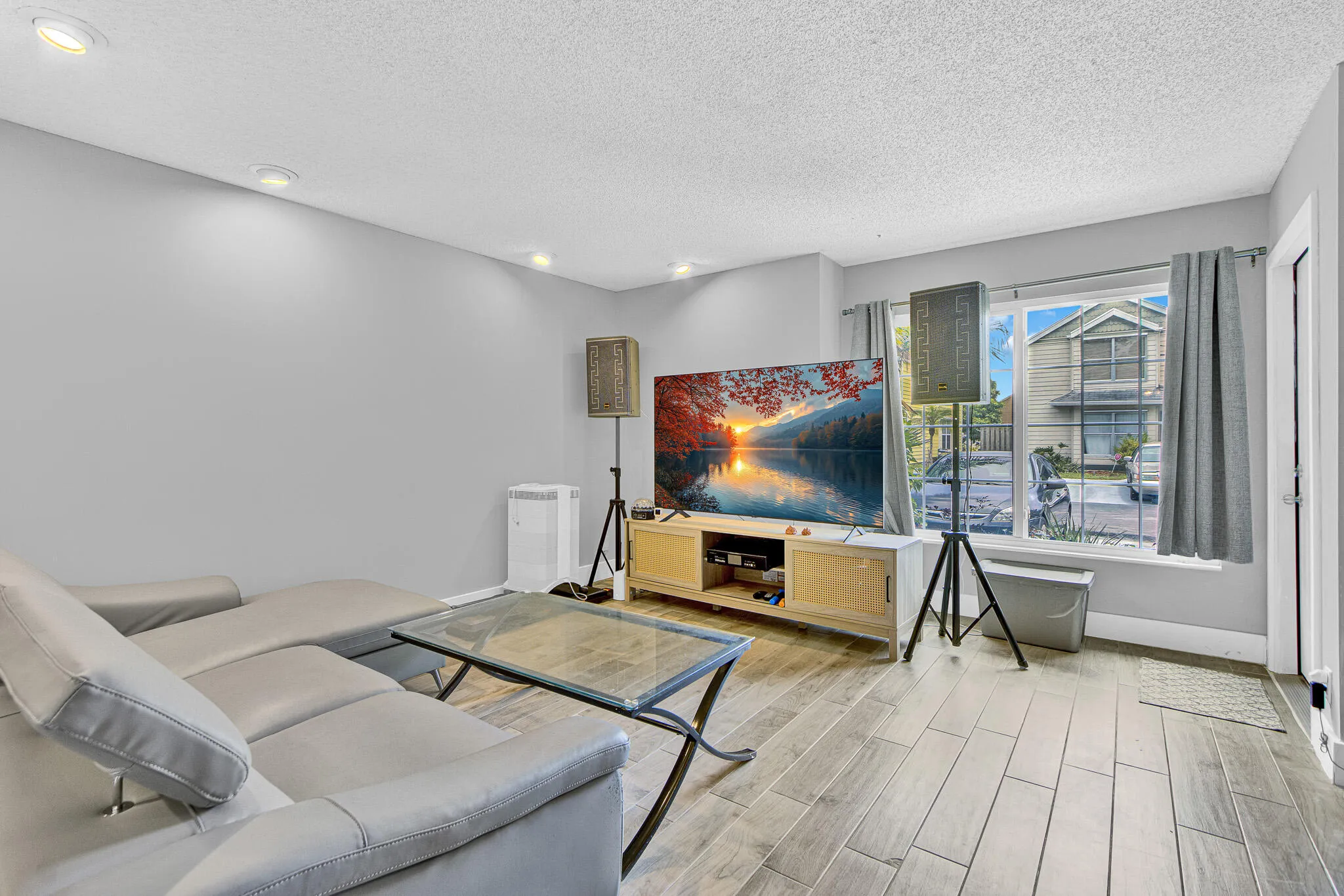 Living area featuring wood-finish flooring, recessed lighting, and a window with natural light