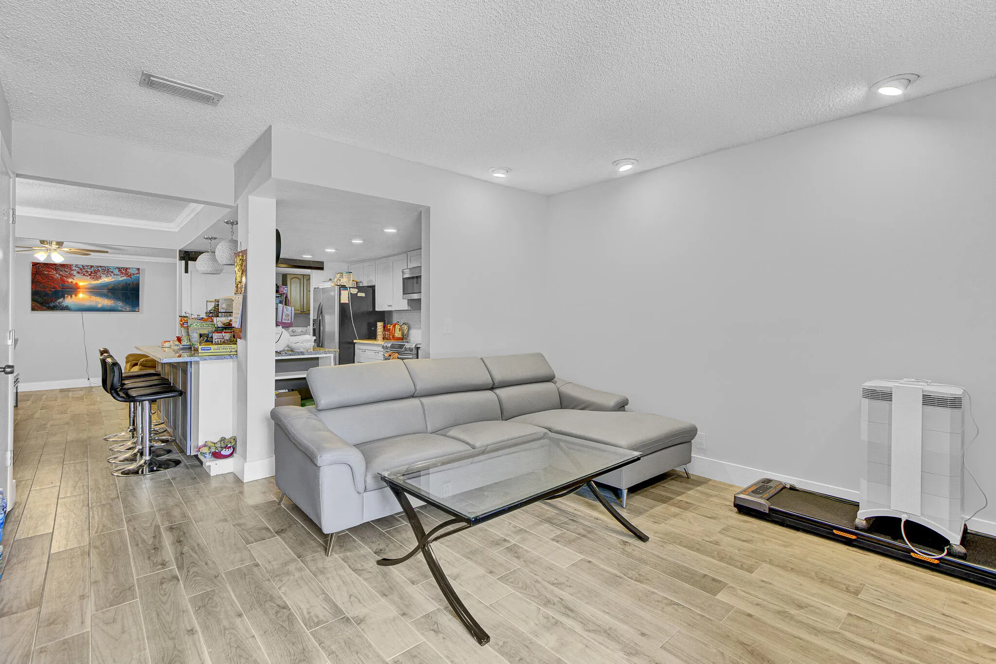 Open-concept living area featuring wood-finish tile flooring and recessed lighting