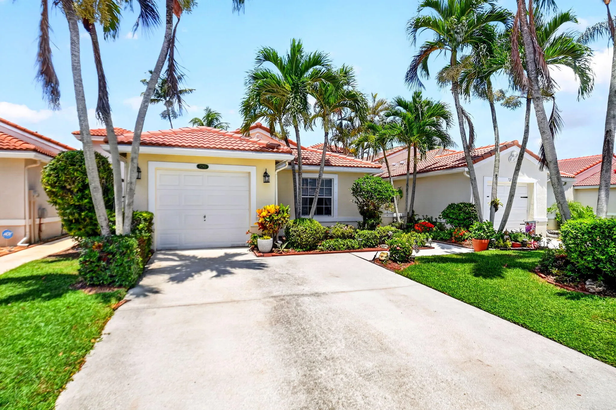 Single-story residence featuring a tile roof, an integrated garage with a white door, and a concrete driveway
