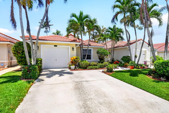 Single-story residence featuring a tile roof, an integrated garage with a white door, and a concrete driveway