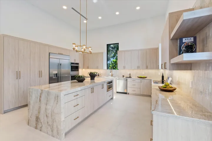 Oversized kitchen with Taj Mahal Quartzite, dual ovens and lots of natural light