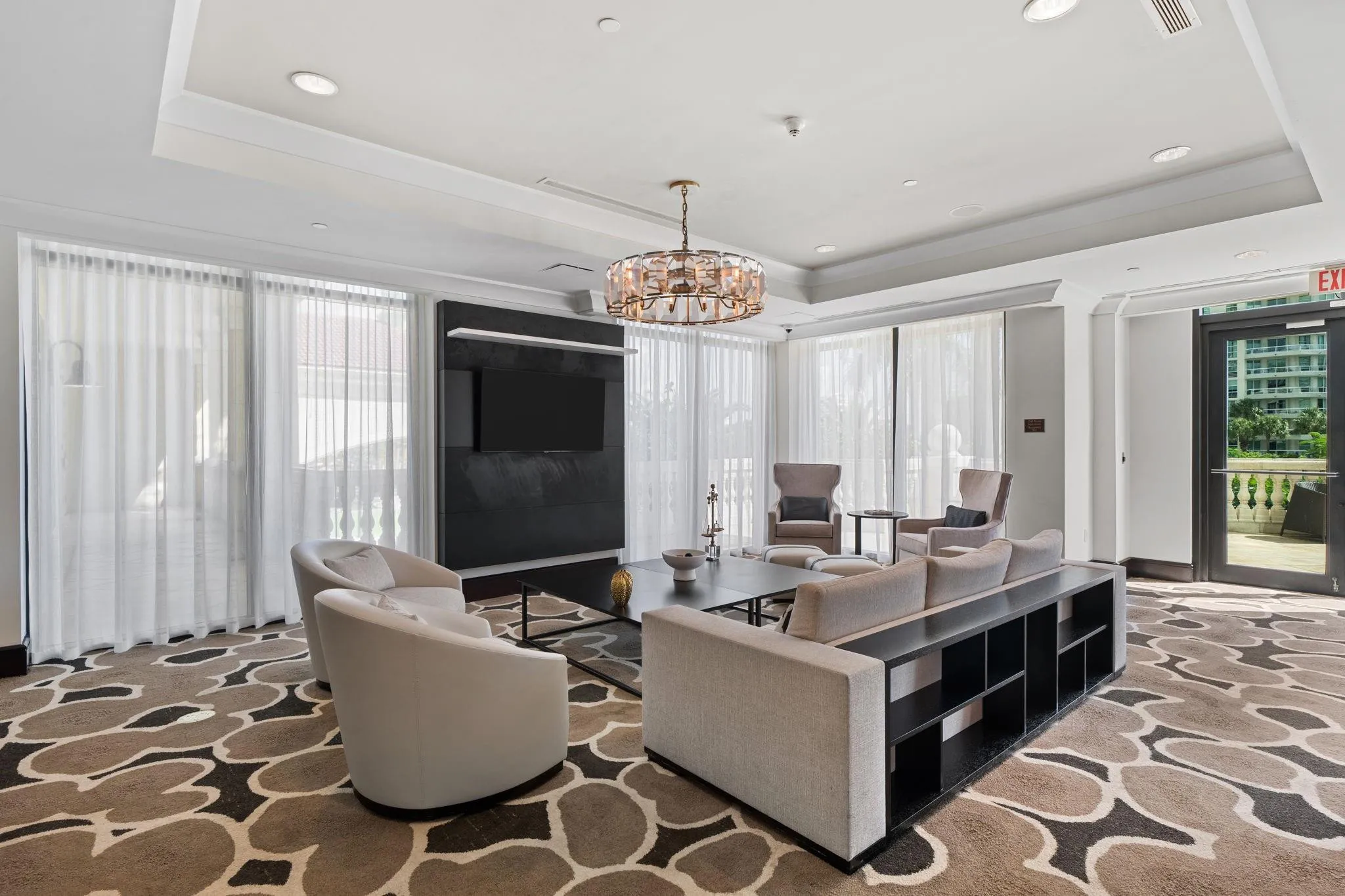Spacious club room lounge with multiple seating areas & direct access to the outdoor waterfront terrace.
