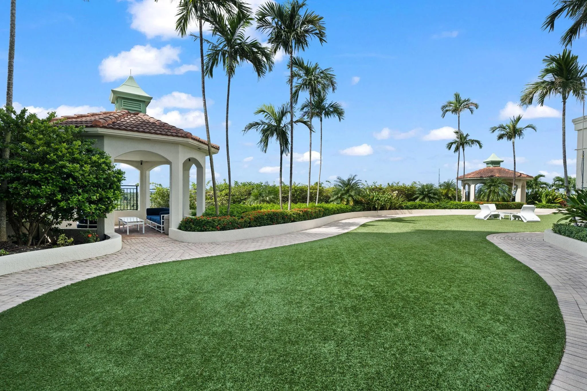Landscaped lawn with lounge chairs, walking paths, shaded gazebo seating & space for outdoor gatherings.