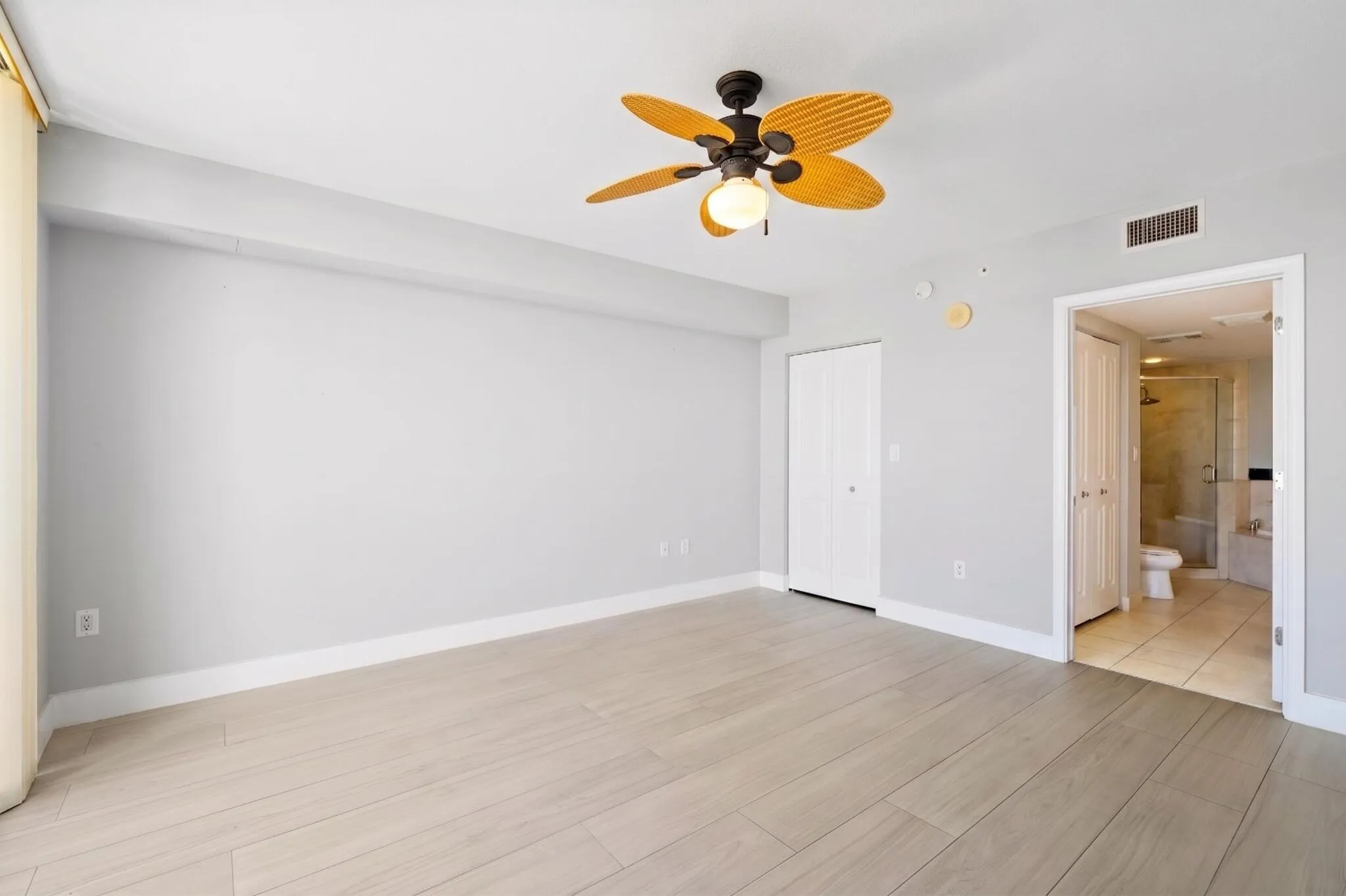 Additional view of the bright main suite, offering a flexible furniture layout, ceiling fan & private ensuite bath.