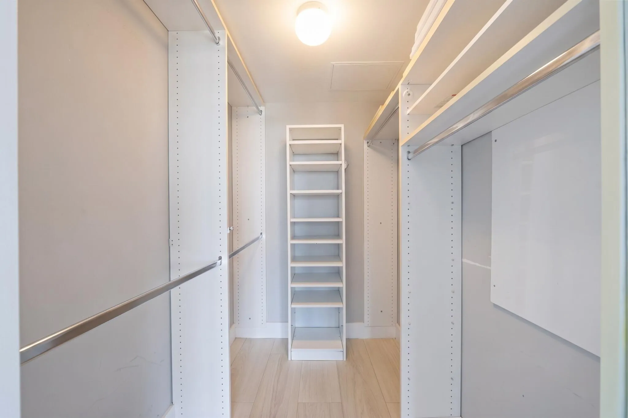 Walk-in closet with extensive custom built-ins, including shelving, drawers, hanging space & dedicated shoe storage.