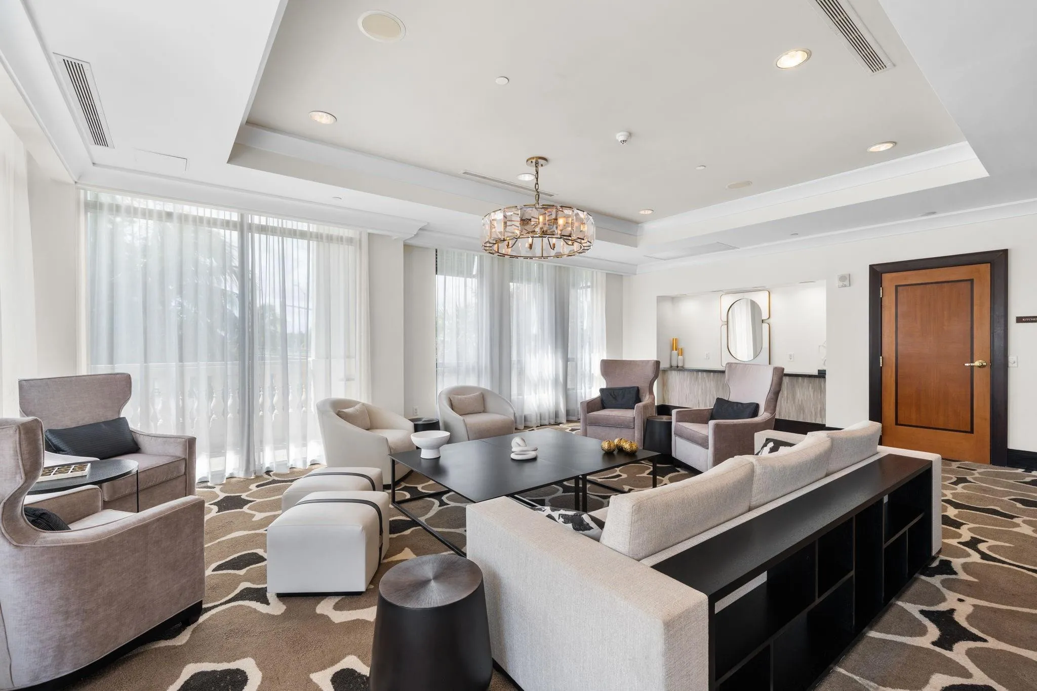 Alternate view of the club room featuring a large gathering space, comfortable seating, television & terrace access.