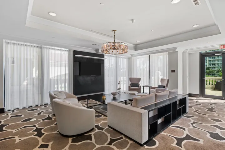 Spacious club room lounge with multiple seating areas & direct access to the outdoor waterfront terrace.