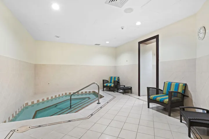 Spa area with an indoor whirlpool & lounge seating for post-workout relaxation.