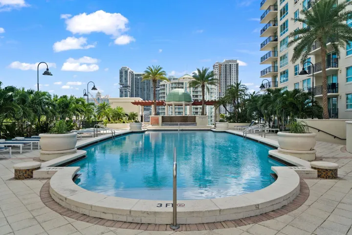 Heated pool surrounded by tropical landscaping, lounge seating & a resort-style sun deck.