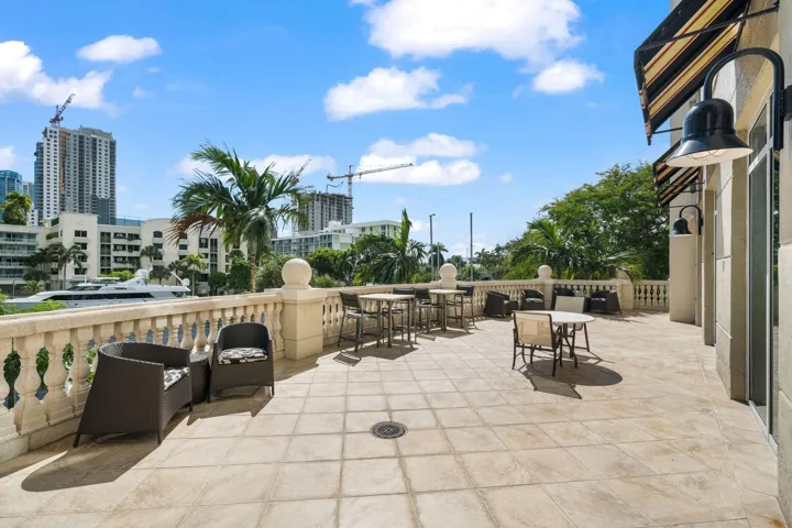 Outdoor waterfront patio with lounge & dining seating overlooking the private marina & New River.