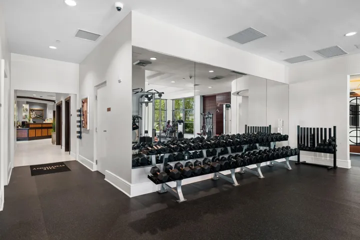 Dedicated free-weight area with dumbbells, mirrored walls & convenient access to the spa and salon.