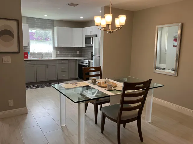Integrated kitchen and dining area featuring light-toned tile flooring
