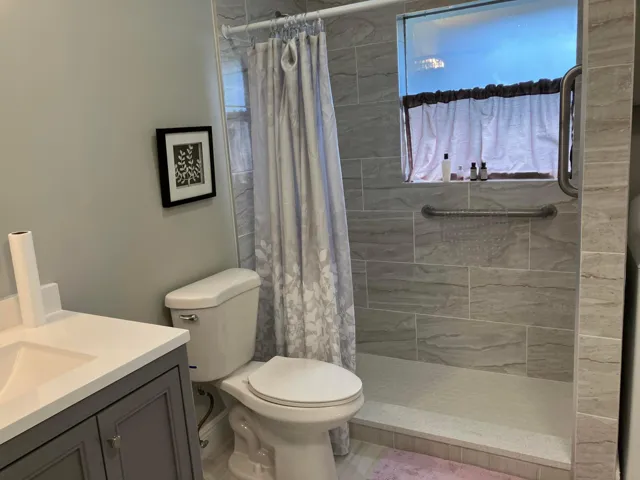 Shower stall featuring horizontal tile work and an integrated window