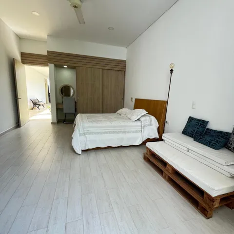 Spacious room featuring light-toned wood-finish flooring and a built-in wood-paneled wardrobe with sliding doors
