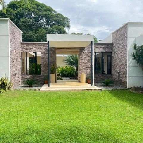 Contemporary exterior showcasing stacked stone accents and a covered entry