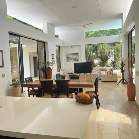 Open-concept living space featuring high ceilings, clerestory windows, and large format tile flooring