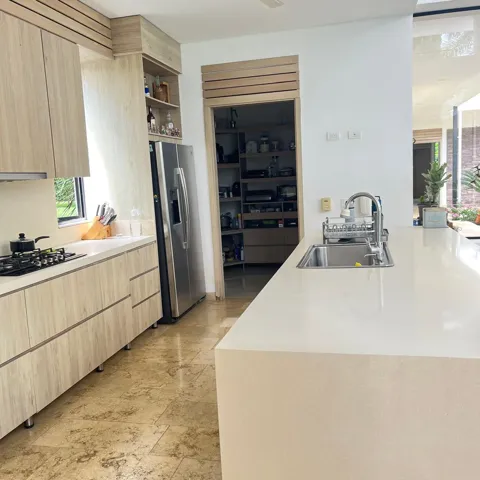 Contemporary kitchen featuring wood-finish cabinetry and a large center island with an undermount stainless steel sink