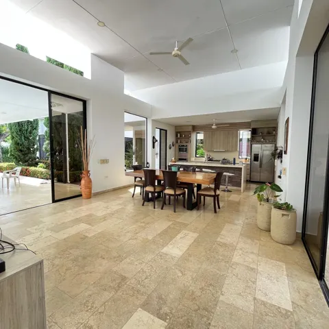 Spacious open-concept living area featuring light-toned tile flooring throughout