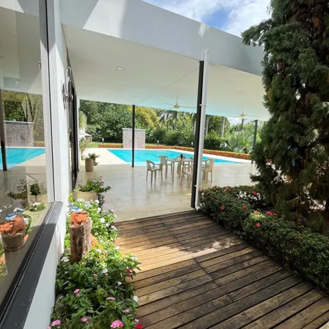 Spacious outdoor patio with overhead coverage, ceiling fans, and concrete flooring