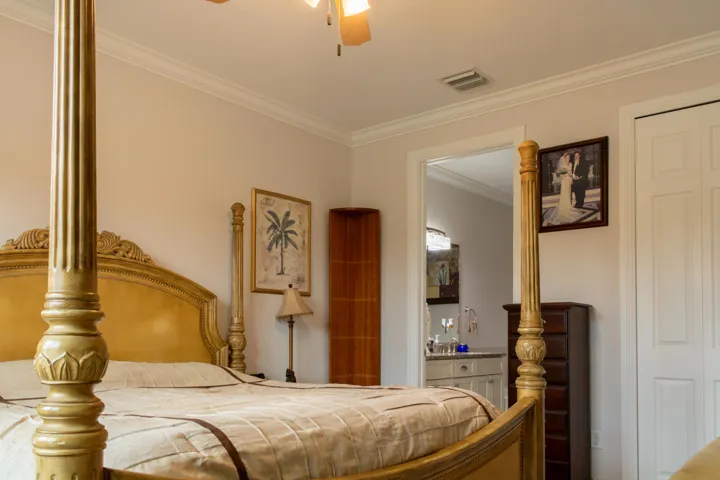 Bedroom featuring crown molding, neutral wall color, and white bi-fold closet doors