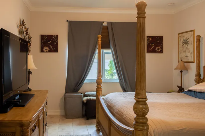 Spacious room featuring neutral wall tones, crown molding, a window with horizontal blinds and drapery, and tile flooring