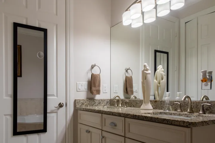 Double vanity featuring a granite countertop with integrated sinks, brushed nickel faucets, and coordinating hardware