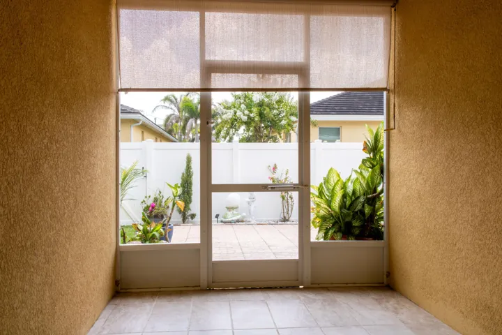 Enclosed patio space featuring textured walls and tiled flooring