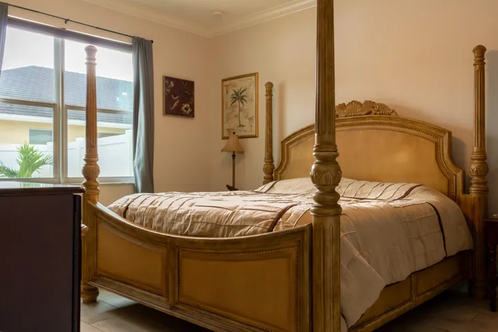 Windowed interior space featuring neutral wall tones, crown molding, and tile flooring