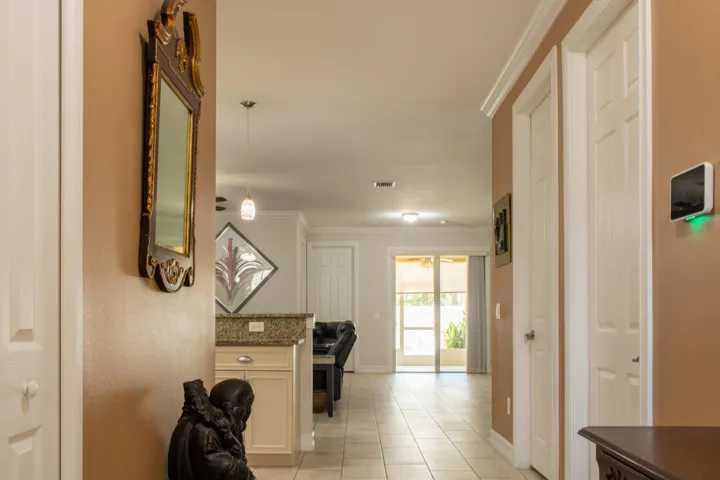Tiled entryway featuring a recessed ceiling light, white paneled doors, and a decorative mirror